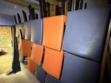 several orange and blue refrigerators are lined up in a room