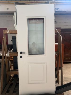 une porte blanche avec une vitre dans une pièce