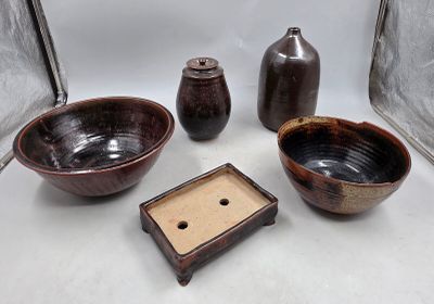 trois bols et deux vases posés sur une table