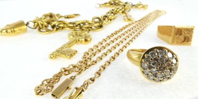 a lot of gold jewelry on a white surface