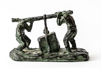 statue of two men carrying a large piece of wood on a rock