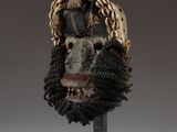 a close up of a mask on a stand on a white surface