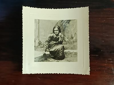 une vieille photo d'une femme agenouillée par terre