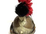 a helmet with a red feather on top of it