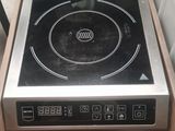 une plaque de cuisson noire et argentée dans une boîte en bois