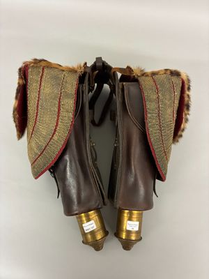 une paire de bottes en cuir marron, doublées de fourrure et ornées de détails dorés