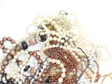 a pile of pearls and other jewelry on a white surface