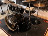 a black drum set sitting on top of a rug in a room