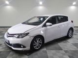 La Toyota Corolla blanche est garée sur un sol en carrelage à damier.