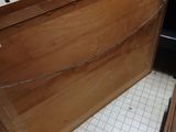 a wooden cabinet with a door open in a kitchen
