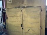 une grande porte en bois au milieu d'une pièce