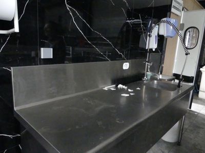 une photo d'un évier en acier inoxydable dans des toilettes publiques