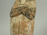 une vieille figurine représentant une femme coiffée d'un chapeau