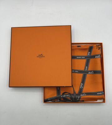 une boîte orange contenant une cravate et une paire de lunettes