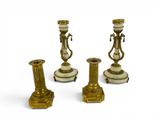 three antique brass candlesticks are sitting on a white surface