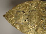 a close up of a gold plate with flowers on it