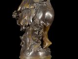 bronze statue of a man riding a horse with a bird on its back
