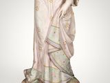 a figurine of a woman in a blue dress holding a flower