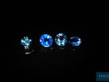 un ensemble de trois saphirs bleus posés sur une surface noire