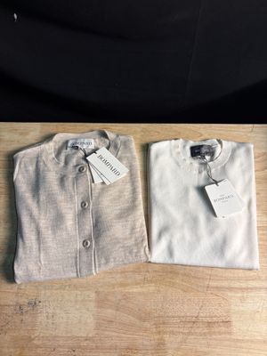 La chemise est blanche et comporte une étiquette.