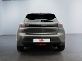 the rear end of a silver car in a room with white walls