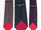 three ties with different designs on them sitting next to each other
