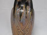 a brown vase that is sitting on a white surface