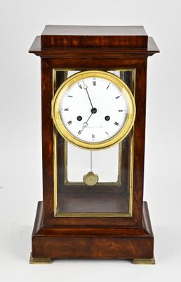 a small wooden clock with a glass case on it