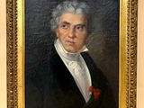 portrait d'un homme en costume noir, une rose rouge à la boutonnière