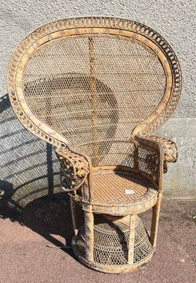 une chaise en osier posée sur le trottoir
