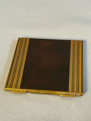 un petit livre doré et noir posé sur une table blanche