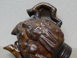 un vase marron surmonté d'un oiseau