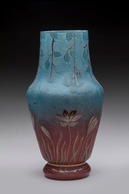 a blue vase with a flower on it sitting on a table