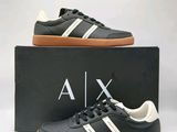 une paire de baskets Adidas noires et blanches dans une boîte