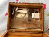 a small wooden box with a lot of items inside of it