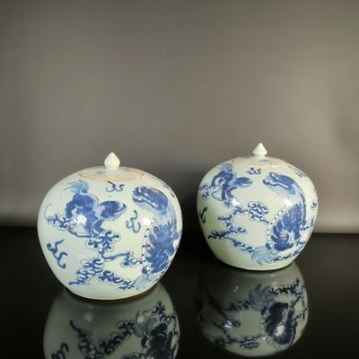 two blue and white vases sitting on a table