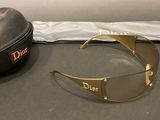 christian dior sunglasses and case on a table next to a bag