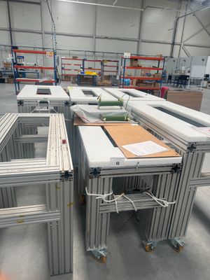 de nombreuses tables qui se trouvent dans un entrepôt où il y a beaucoup de cartons