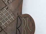 a small wooden object with a design on it