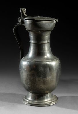 an image of a silver vase with a handle on a table