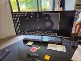 un homme debout devant un bureau d'ordinateur équipé d'un clavier et d'une souris