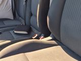 the back seats of a car with a remote control in the passenger seat