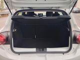 the back of a white car with its trunk open in a parking lot