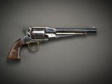 un gros plan d'un revolver sur fond gris