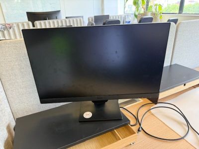 un écran d'ordinateur posé sur un bureau en bois