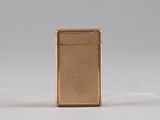 an image of a gold lighter sitting on top of a white surface