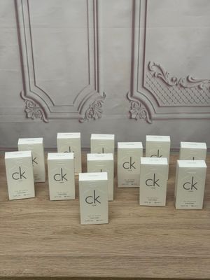 several boxes of perfume sitting on a table in front of a wall