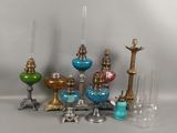 de nombreux vases en verre de différentes couleurs et des bougies sur la table