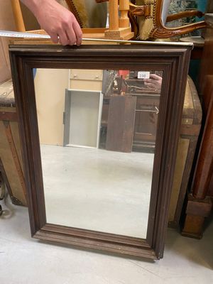 a man standing next to a mirror in a room