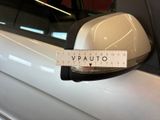 a white car with a measuring tape on it ' s side mirror
